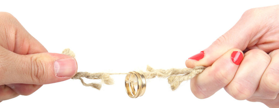 Zwei Hände ziehen an einem Strick, der reißt und an dem ein Ehering hängt | Wohnrecht Scheidung